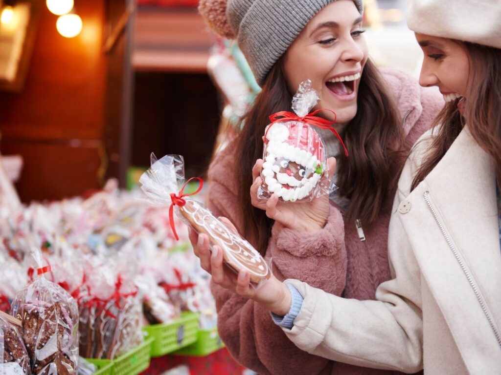 Two women holding Christmas cookies at a market during Easter Events and Activities