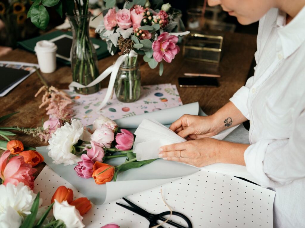 A woman arranging flowers in a vase for a London party, showcasing detailed planning and execution