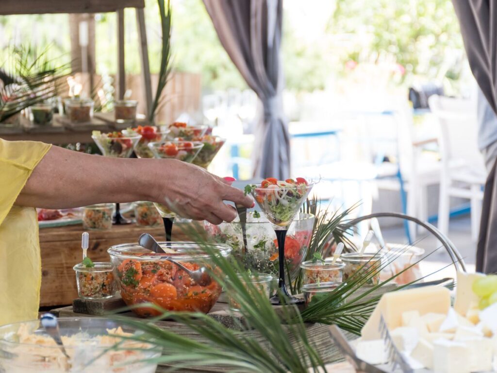A man serving food at a buffet table, adding personal touches to host spectacular London parties